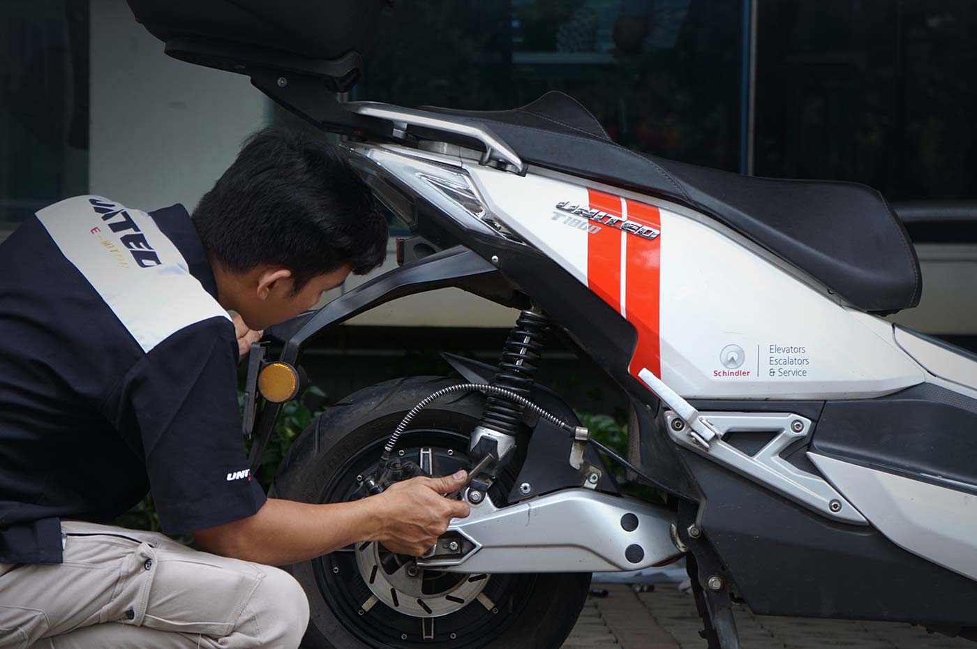 Ilustrasi perawatan motor listrik dengan pengecekan baterai dan komponen penting