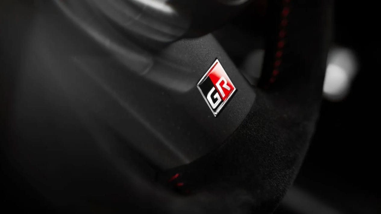 Logo Toyota Gazoo Racing GR pada latar belakang hitam dan merah