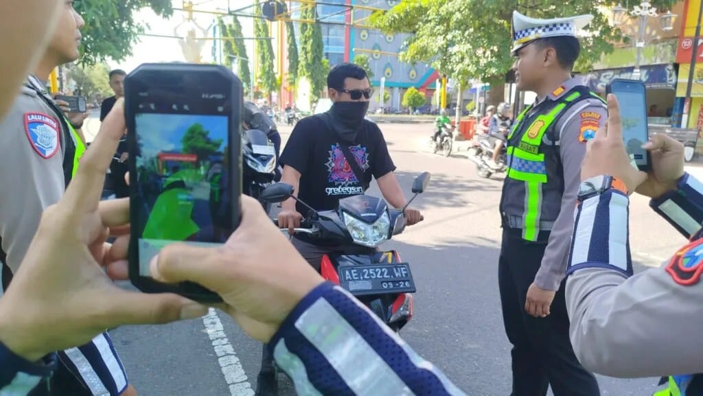 Petugas kepolisian melakukan penindakan tilang ETLE di jalan raya